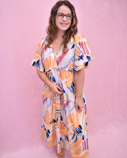 Woman wearing a colorful dress against a pink background