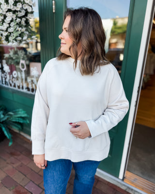 a long sleeve pullover in scuba soft material with a side slit