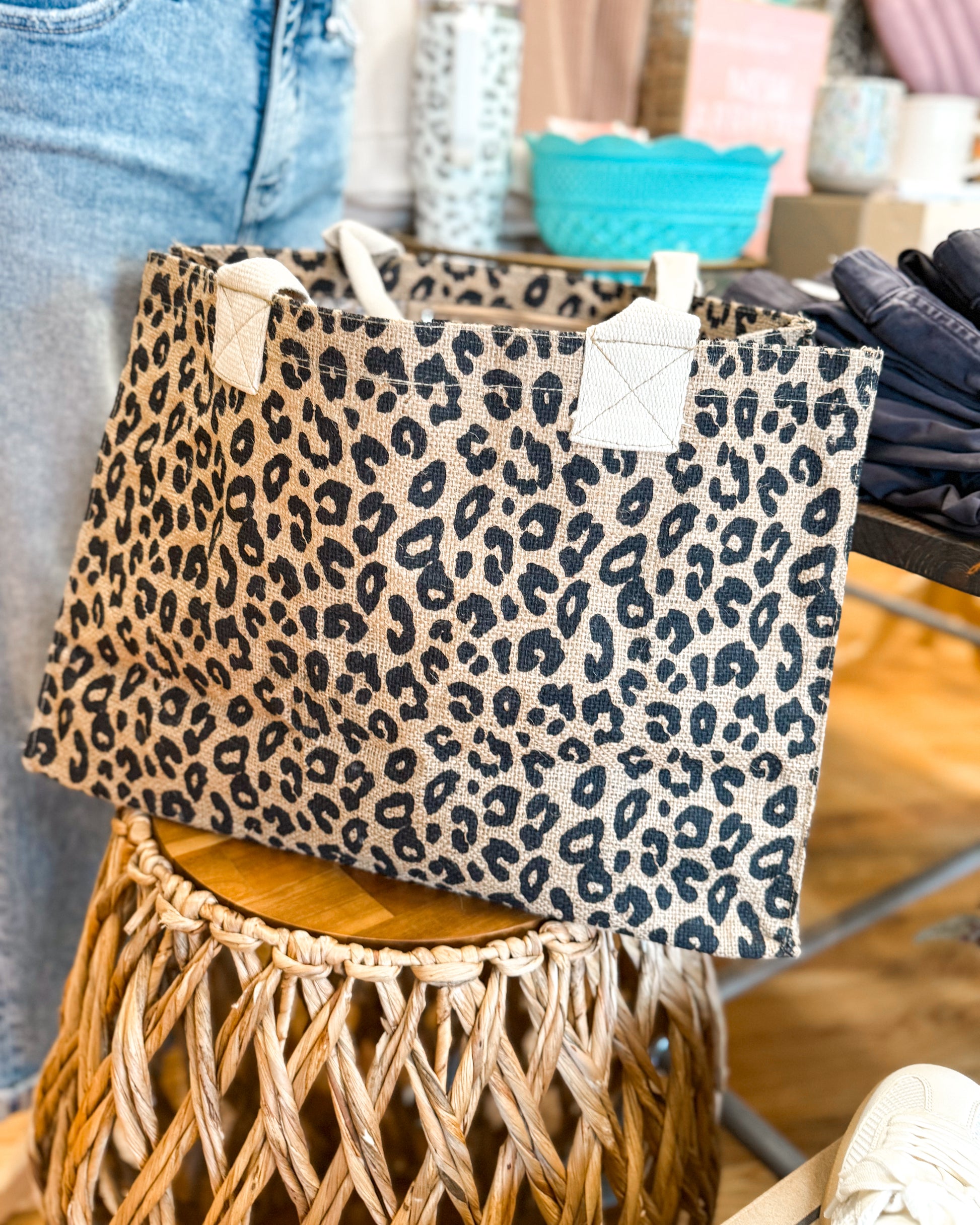 Leopard print bag on a wooden stool with a blurred indoor background