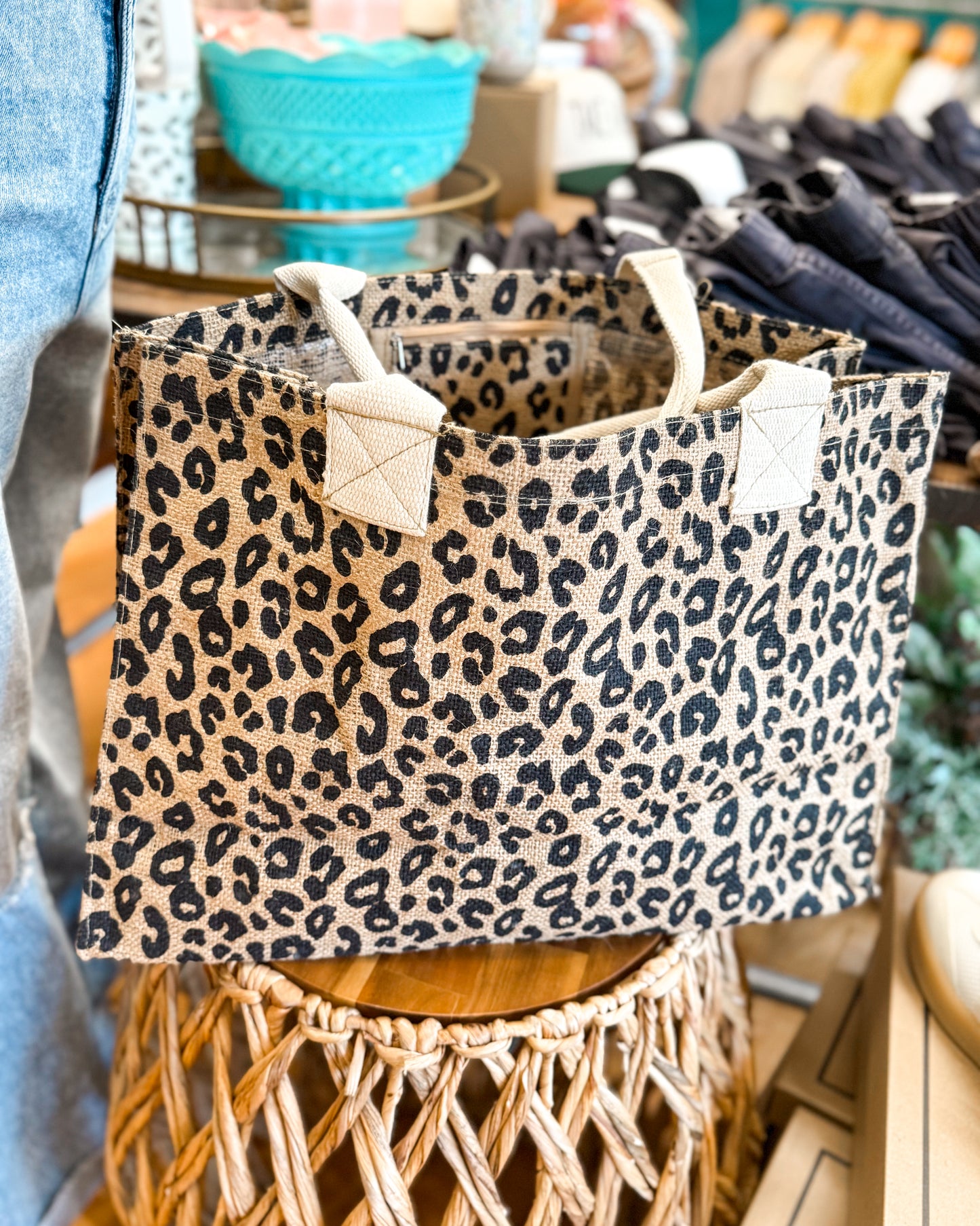Leopard print tote bag on a wooden stool in a store setting