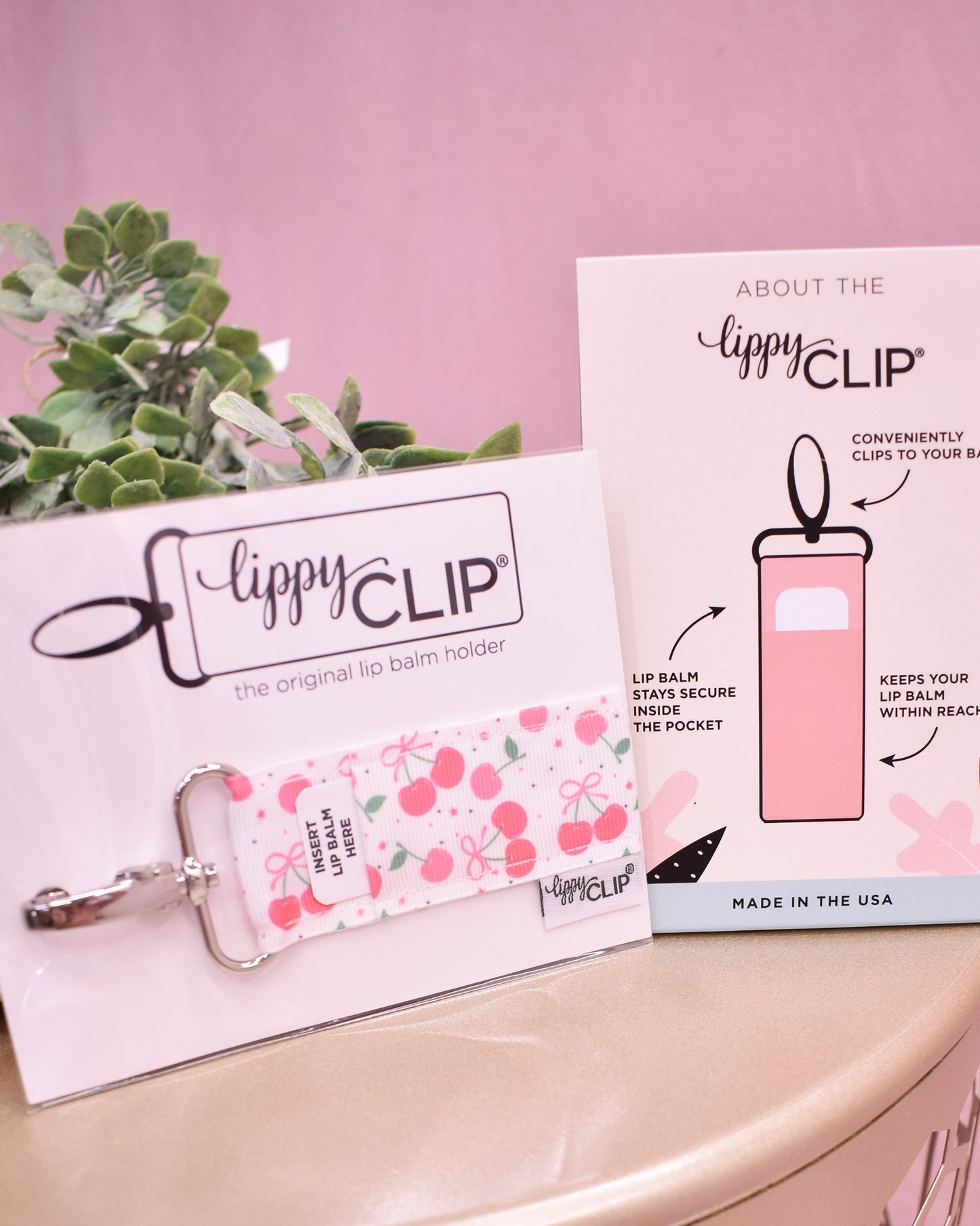 Lippy Clip product with packaging on a pink surface
