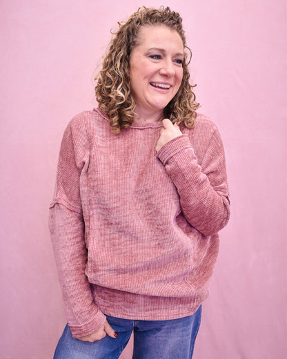 Person wearing a pink textured sweater against a pink background