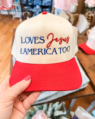 a canvas hat with red bill embroidered with loves Jesus and America too