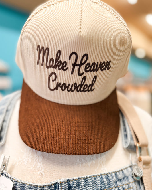 Beige and brown cap with 'Make Heaven Crowded' text worn by a person.