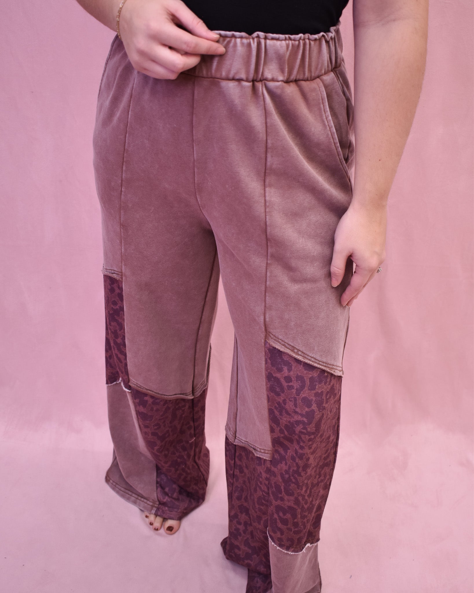 Pink velvet pants with leopard print patchwork on a pink background