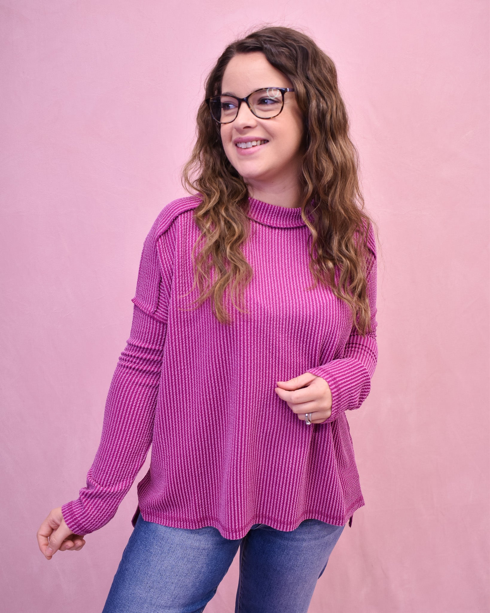 Woman wearing a pink sweater against a pink background
