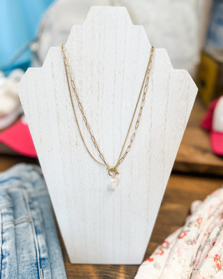 a layered chain with hook and eye clasp and pearl charm