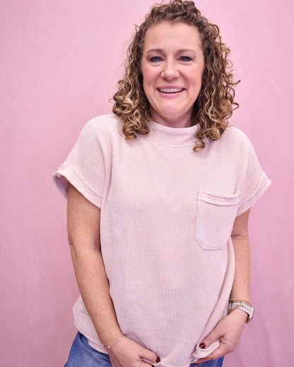 Person wearing a light pink t-shirt against a pink background