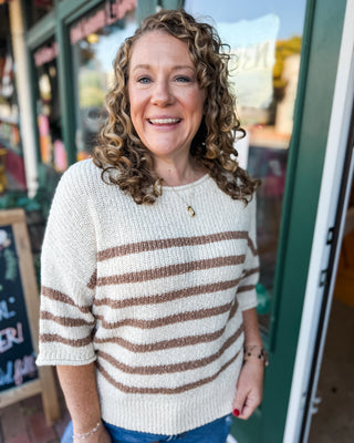 a cream mid length sleeve sweater with mocha stripes