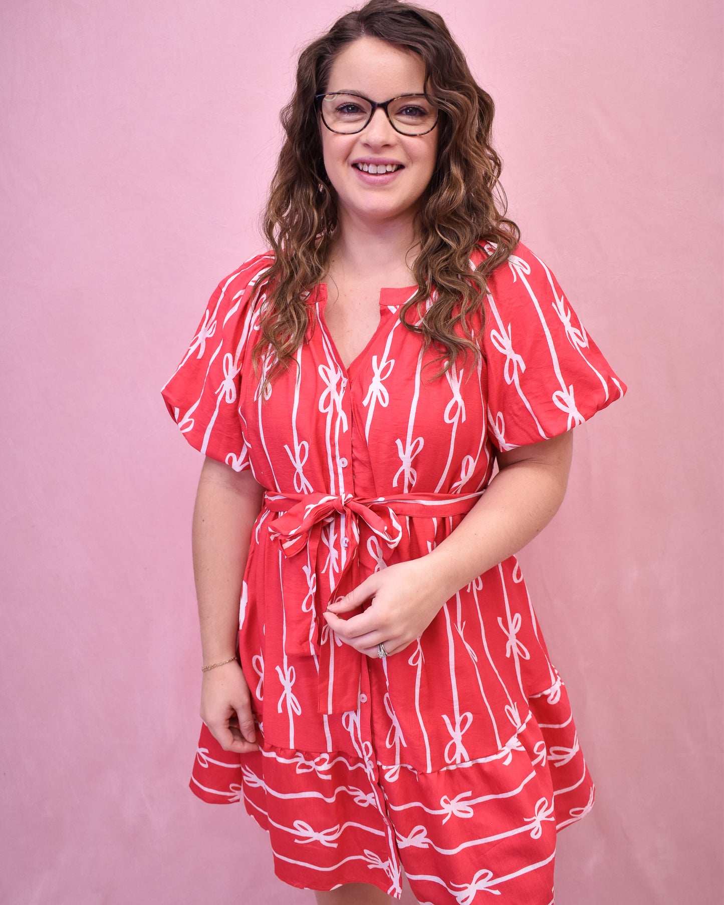 Puff sleeve hot pink dress with buttons down the front and a tie at the waist and bow detail design.