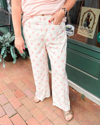 white casual style pants with front pockets and pink polka dots all over.