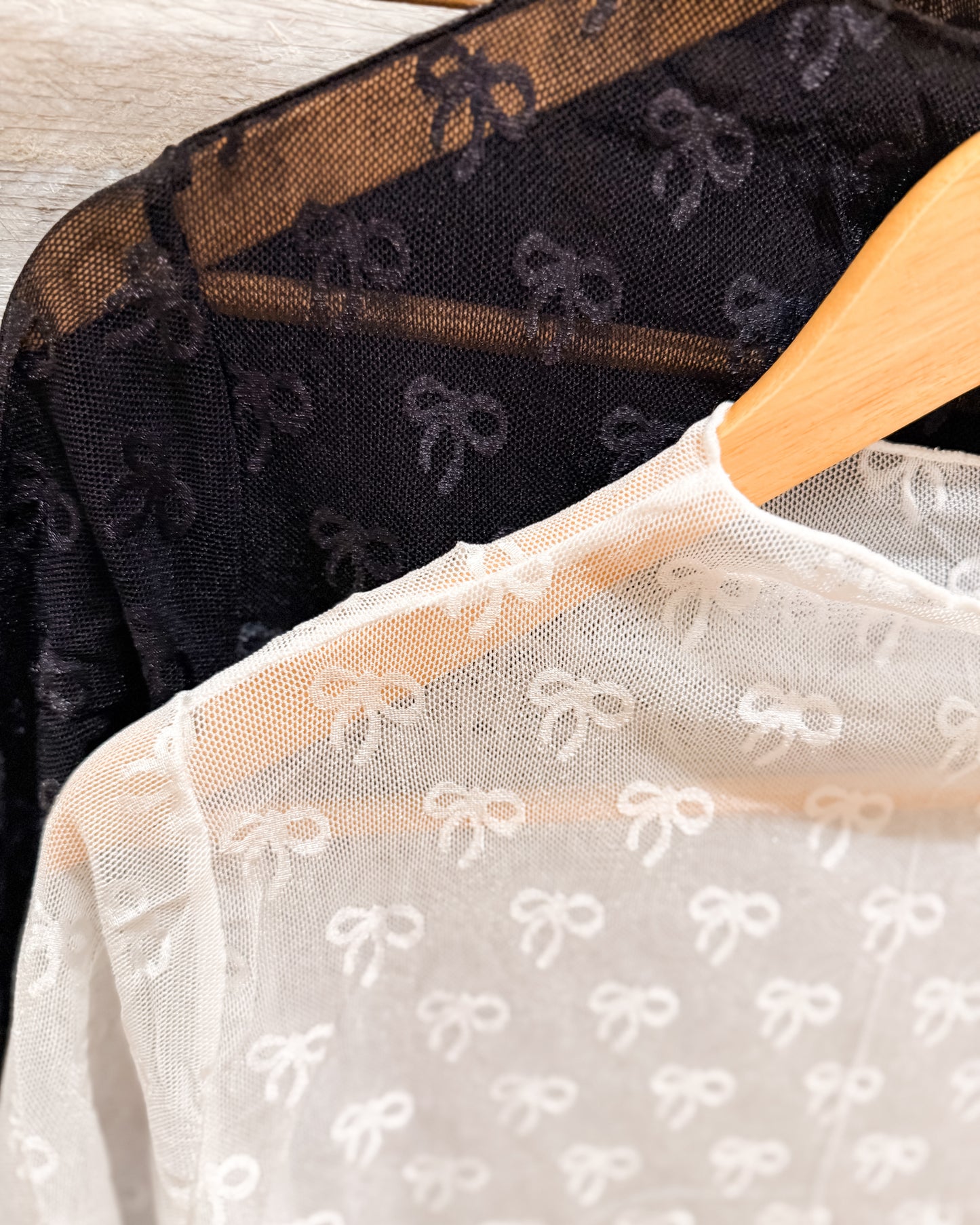 Black and white sheer fabrics with bow pattern on hangers