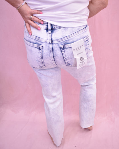 Light blue jeans with a brand tag on a pink background