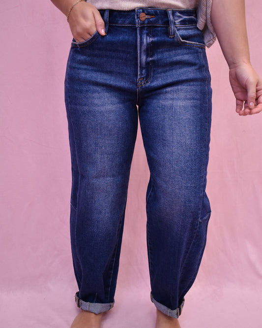Person wearing blue jeans on a pink background