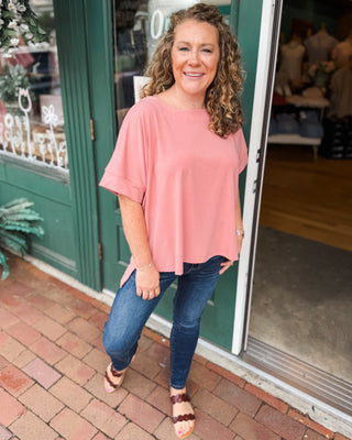 a rose colored scuba style top with a hi-low split hem.