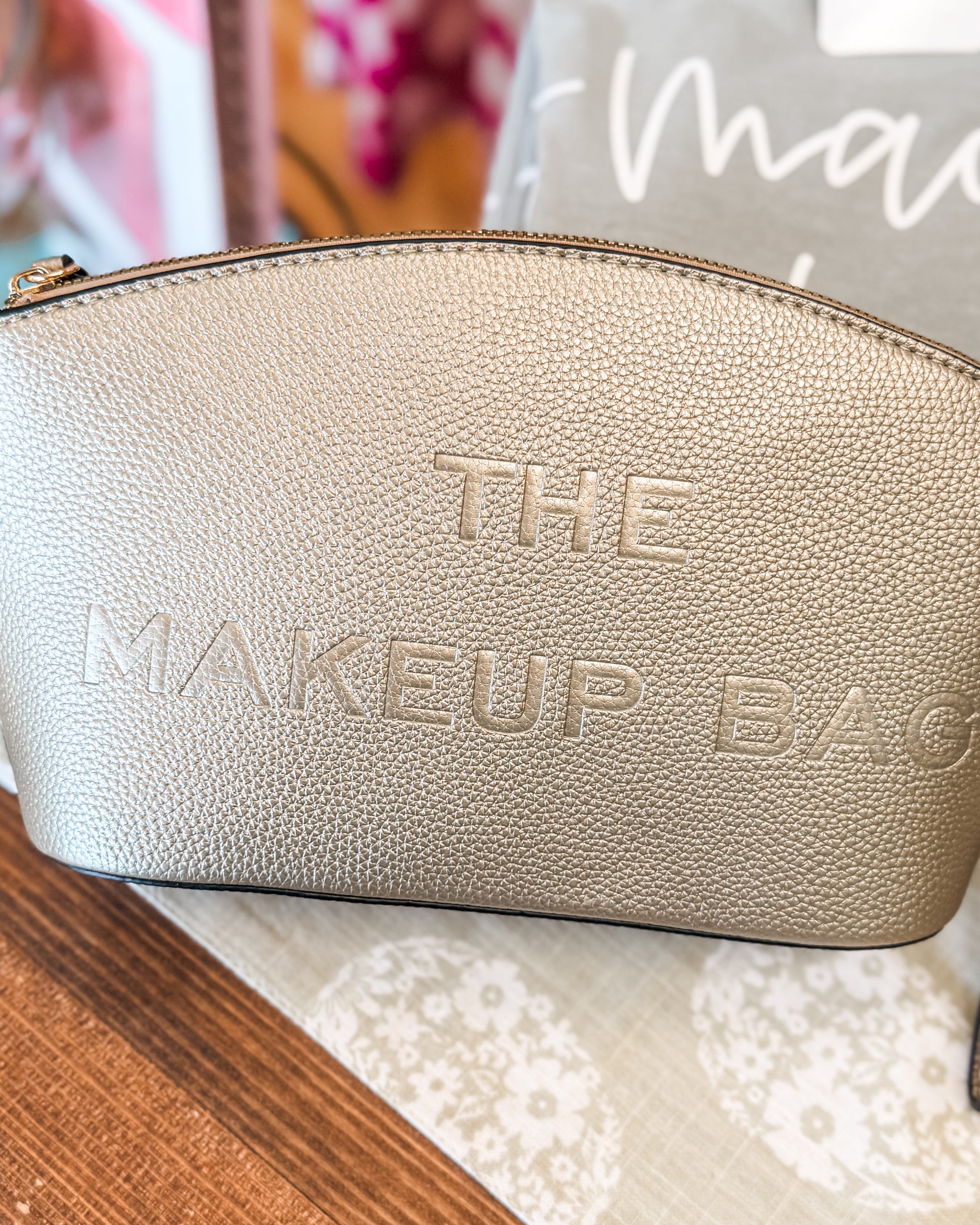 Gold makeup bag embossed with The Makeup Bag