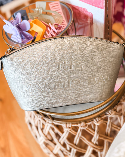 Gold makeup bag with 'The Makeup Bag' text embossed on the bag