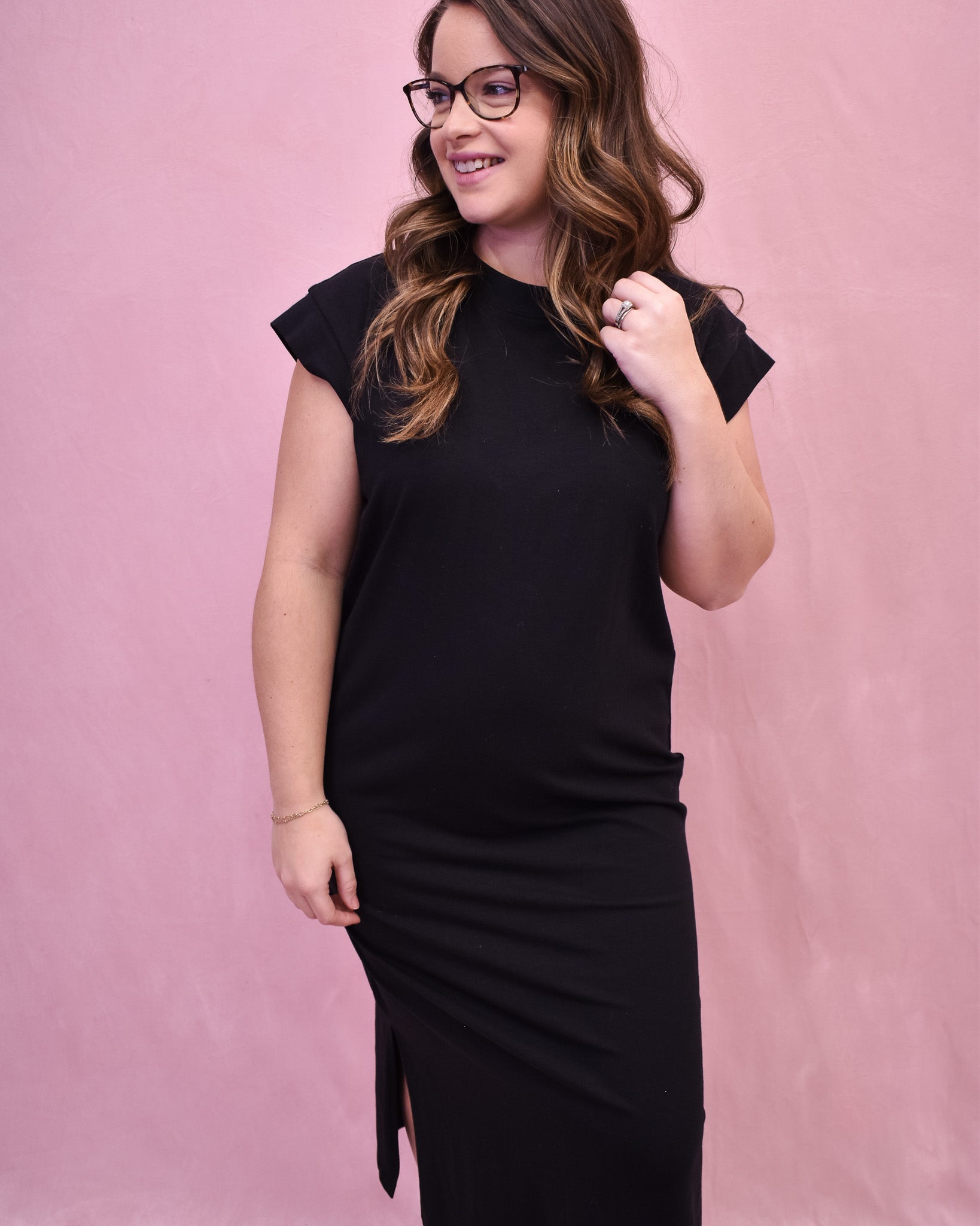 A black midi style dress with rolled sleeves and side slit.