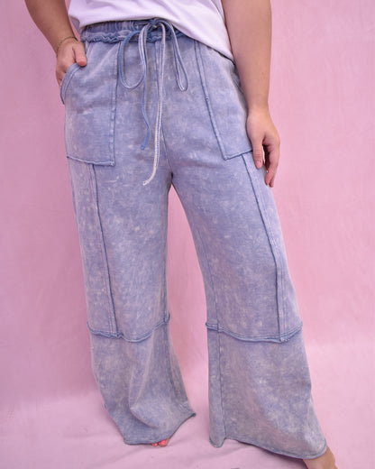 Light blue wide-leg pants with drawstring waist on a pink background