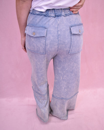 Light blue denim pants with front pocket design on a pink background