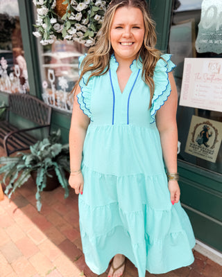 a mint and blue tiered midi dress in a seersucker material with ruffle flutter sleeves and piping details.