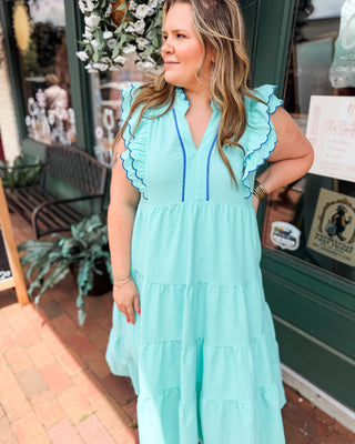 a mint and blue tiered midi dress in a seersucker material with ruffle flutter sleeves and piping details.