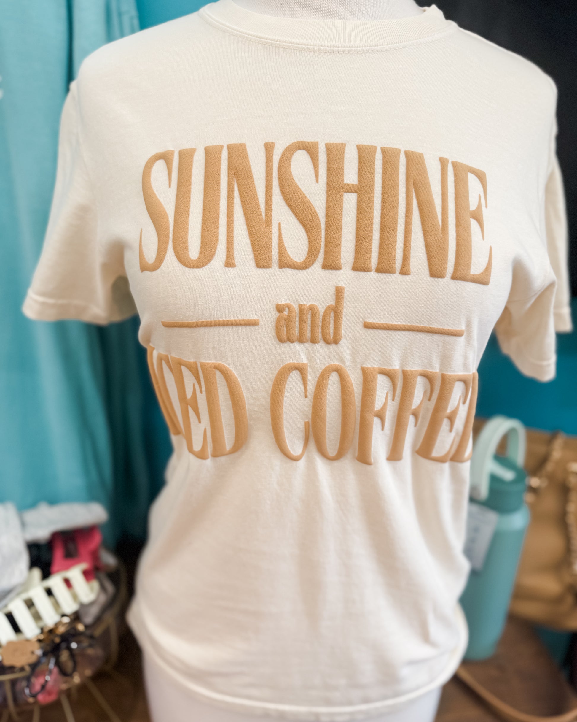 White t-shirt with 'Sunshine andiced Coffee' text on a blue background