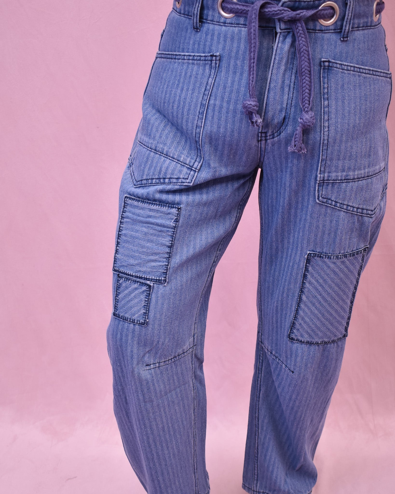 Blue jeans with a drawstring on a pink background