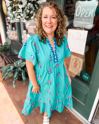 a teal vneck midi dress with embroidered floral patterns 