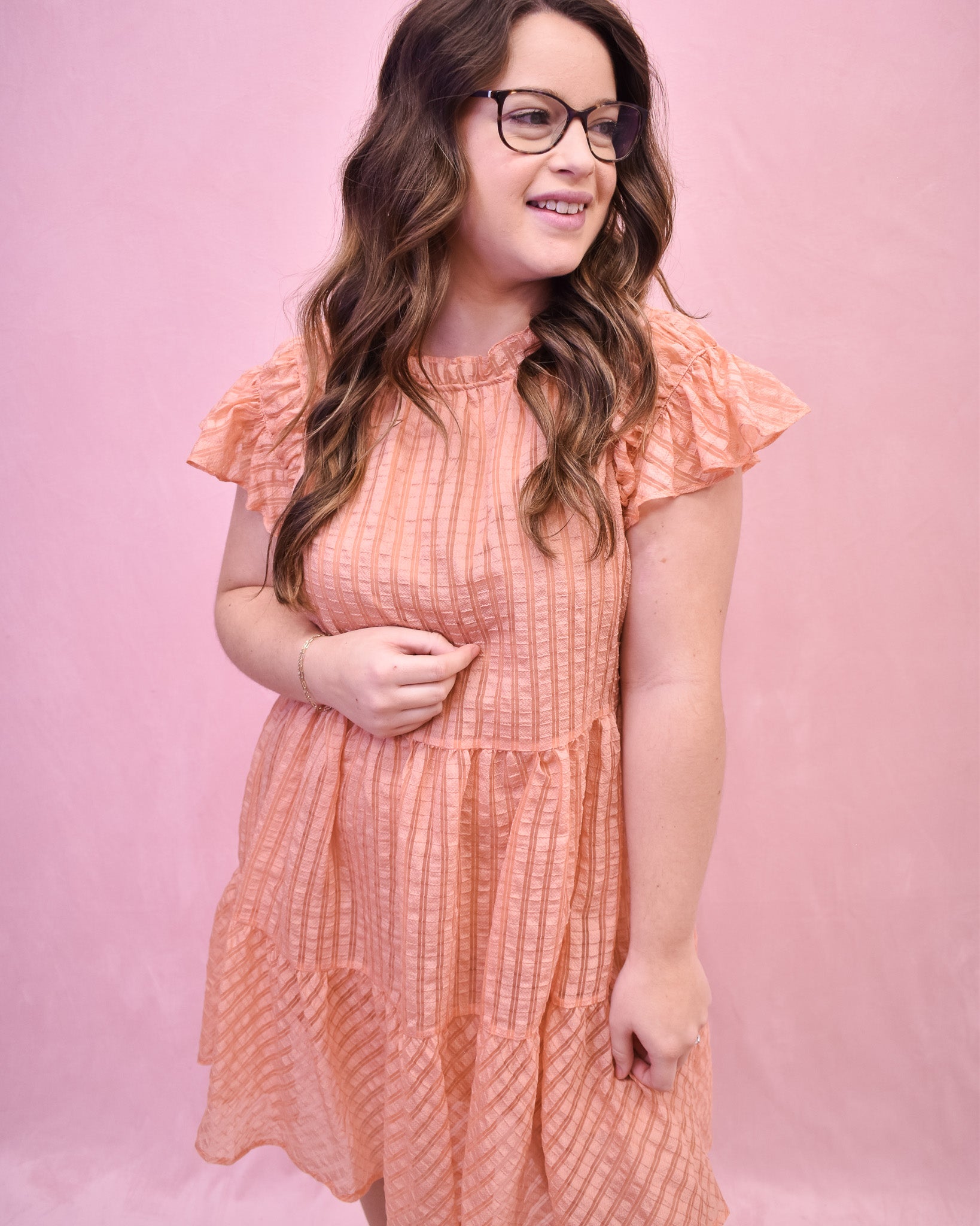 a peach textured mini dress with flutter sleeves