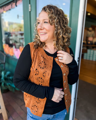 a sleeveless suede laser cutout button down vest in a cognac color.