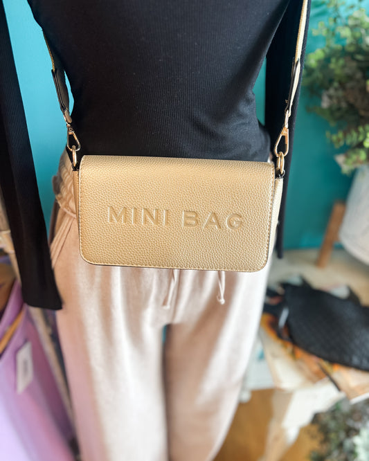 A cute faux leather crossbody purse in gold with mini bag embossed 