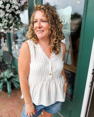 a sleeveless striped peplum button front top
