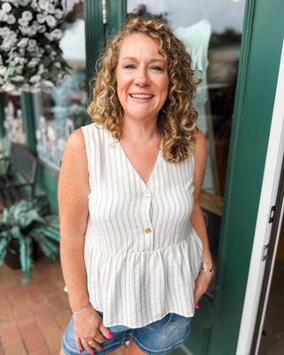 a sleeveless striped peplum button front top