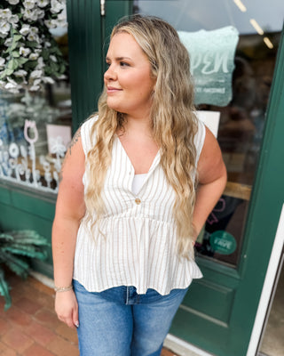 a sleeveless striped peplum button front top