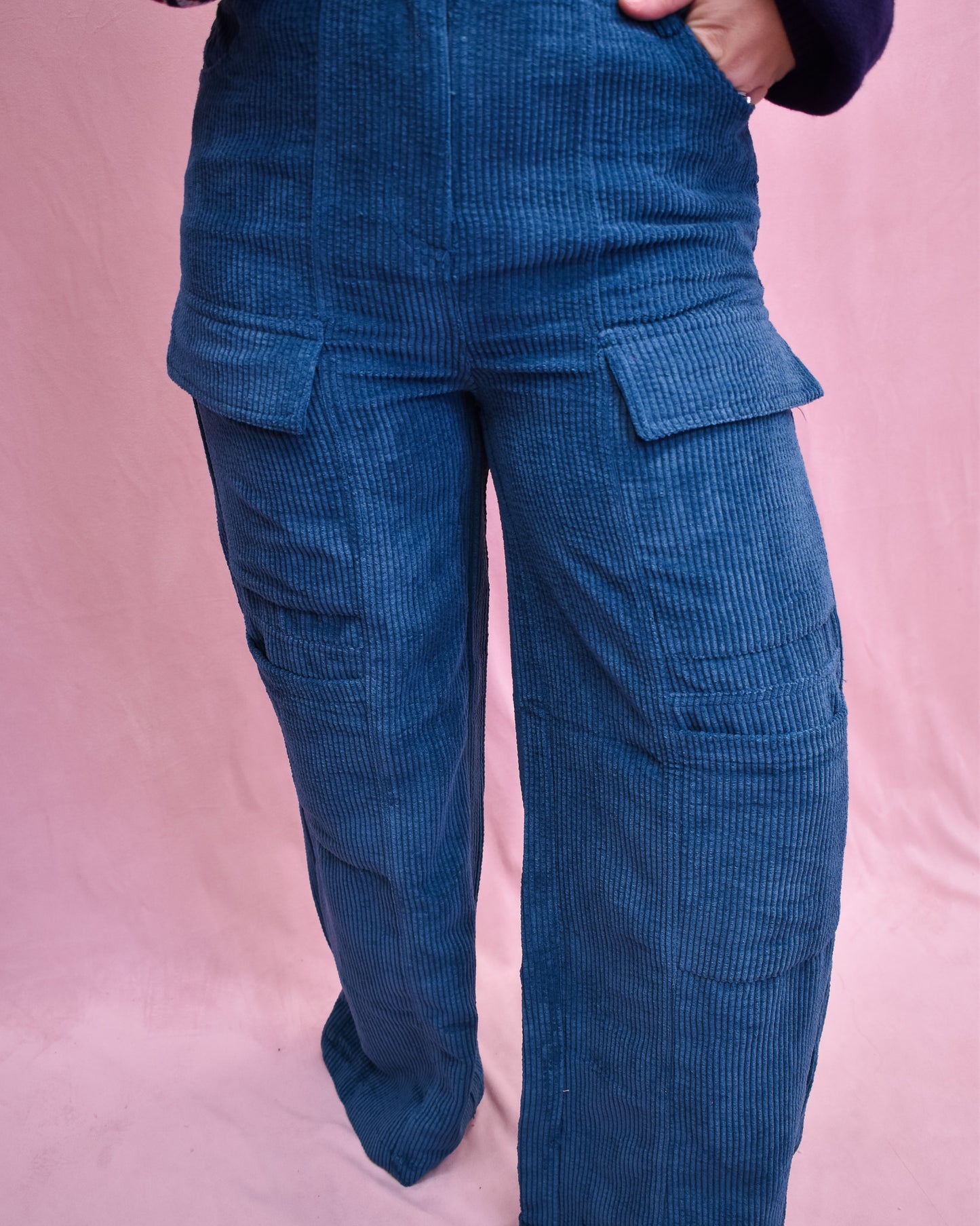 Blue corduroy pants on a pink background