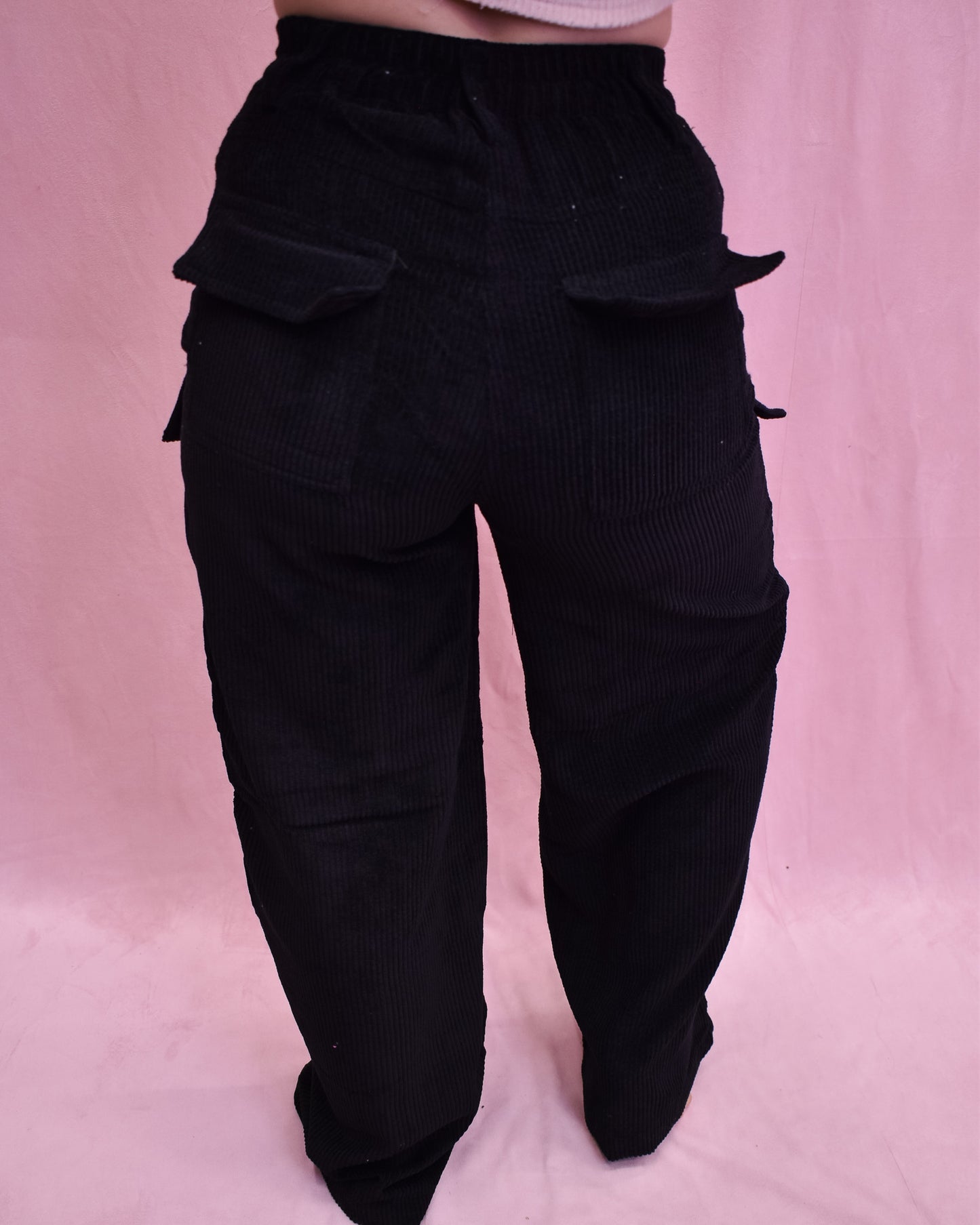 Black cargo pants on a pink background