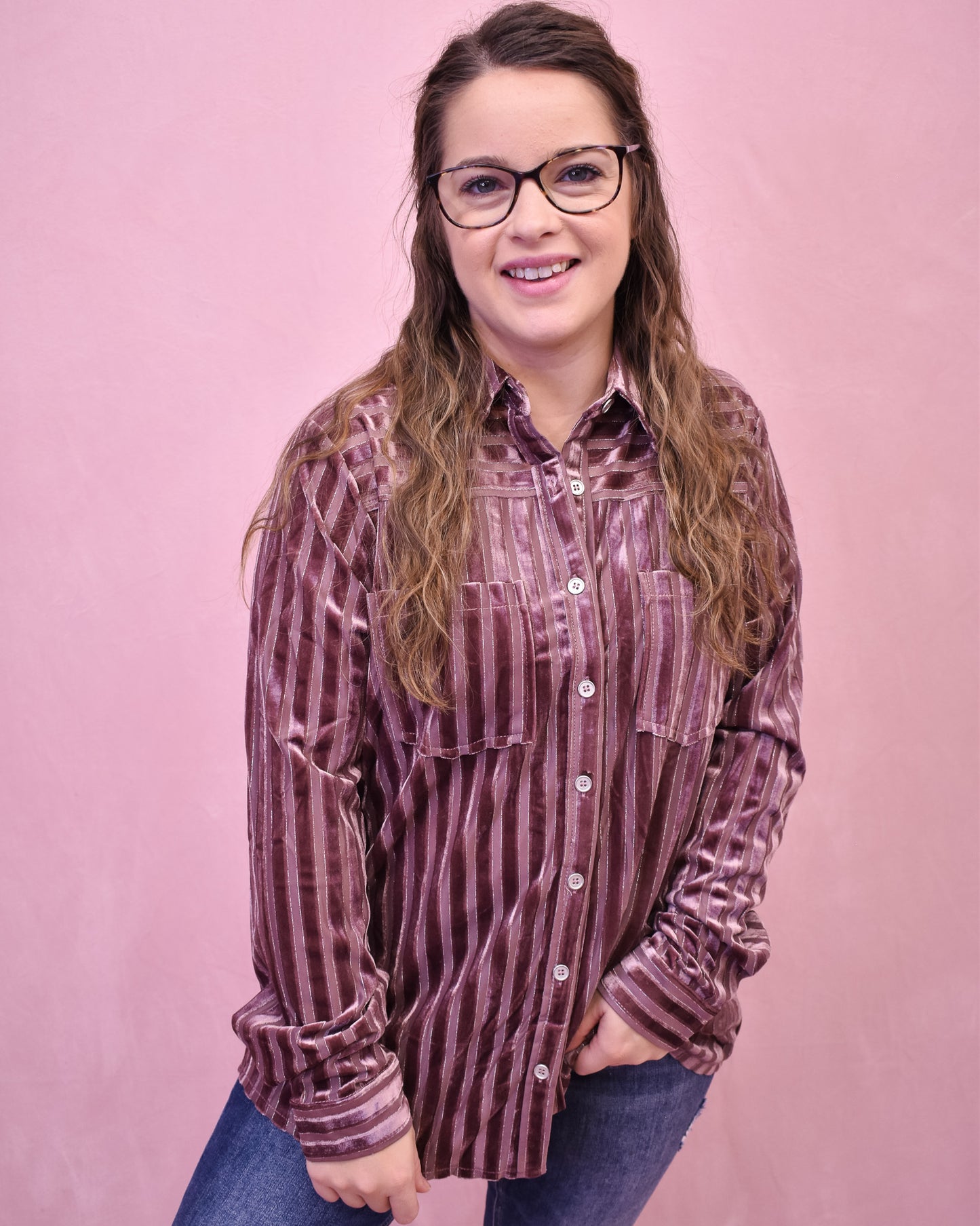 Woman wearing a striped shirt against a pink background
