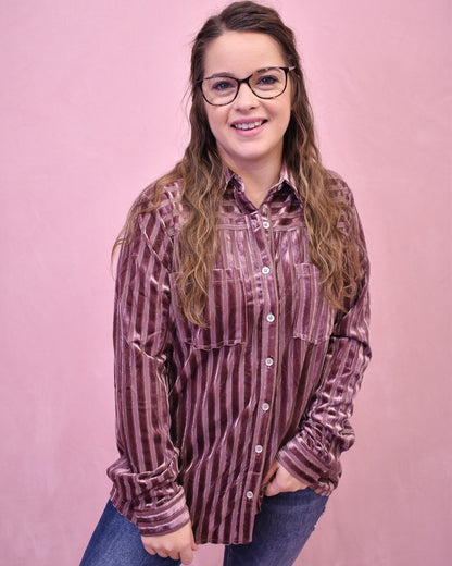 Woman wearing a striped shirt against a pink background