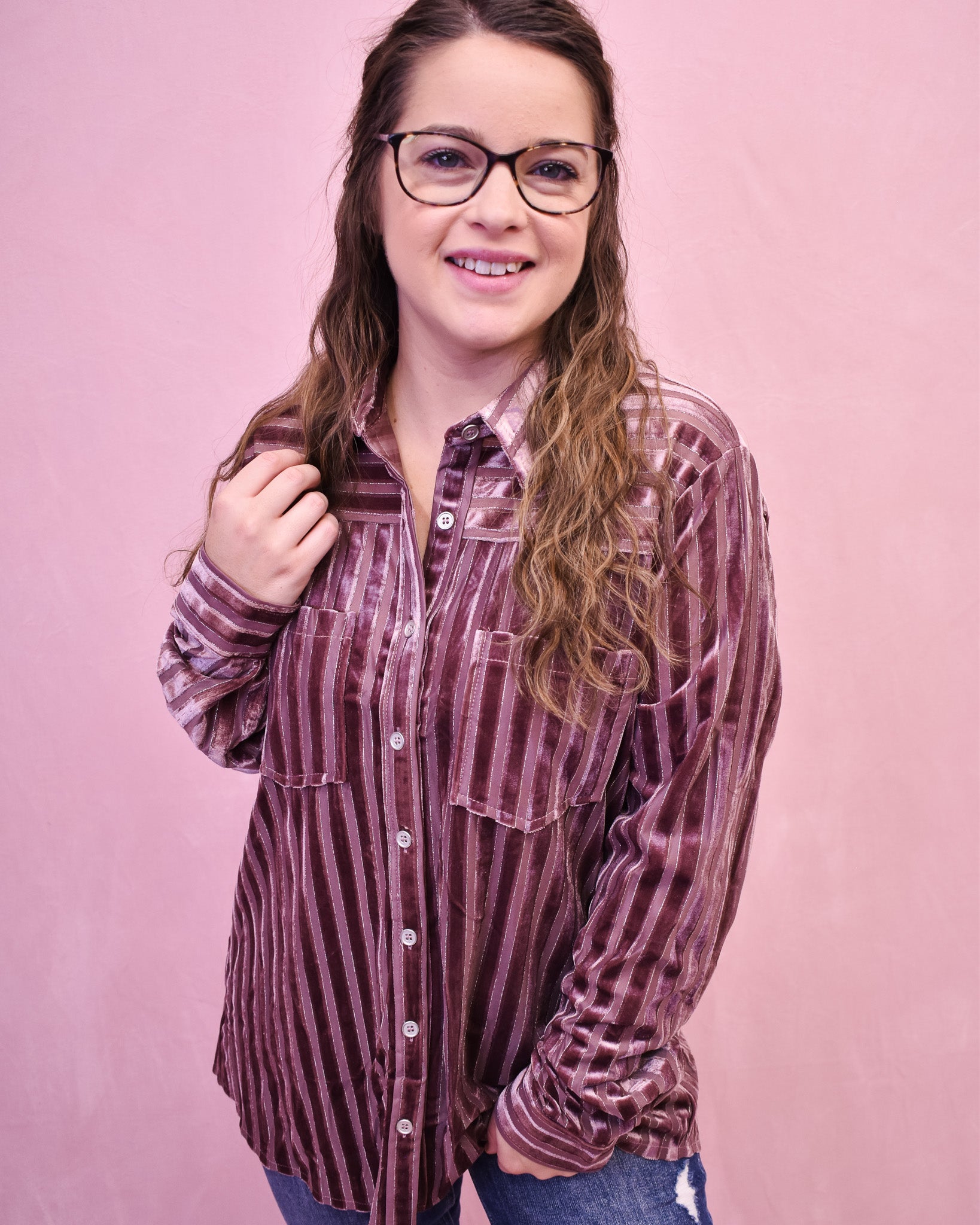 Person wearing a striped shirt against a pink background